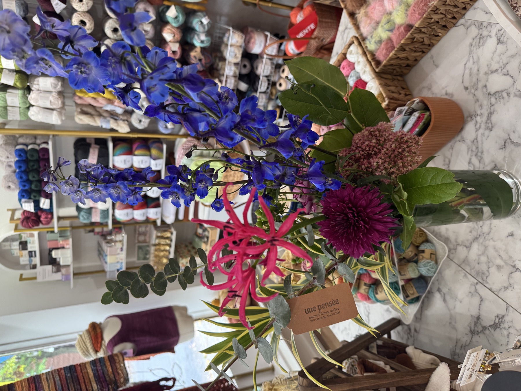 Bouquet de fleurs dans la boutique Mamou, entouré de laines
